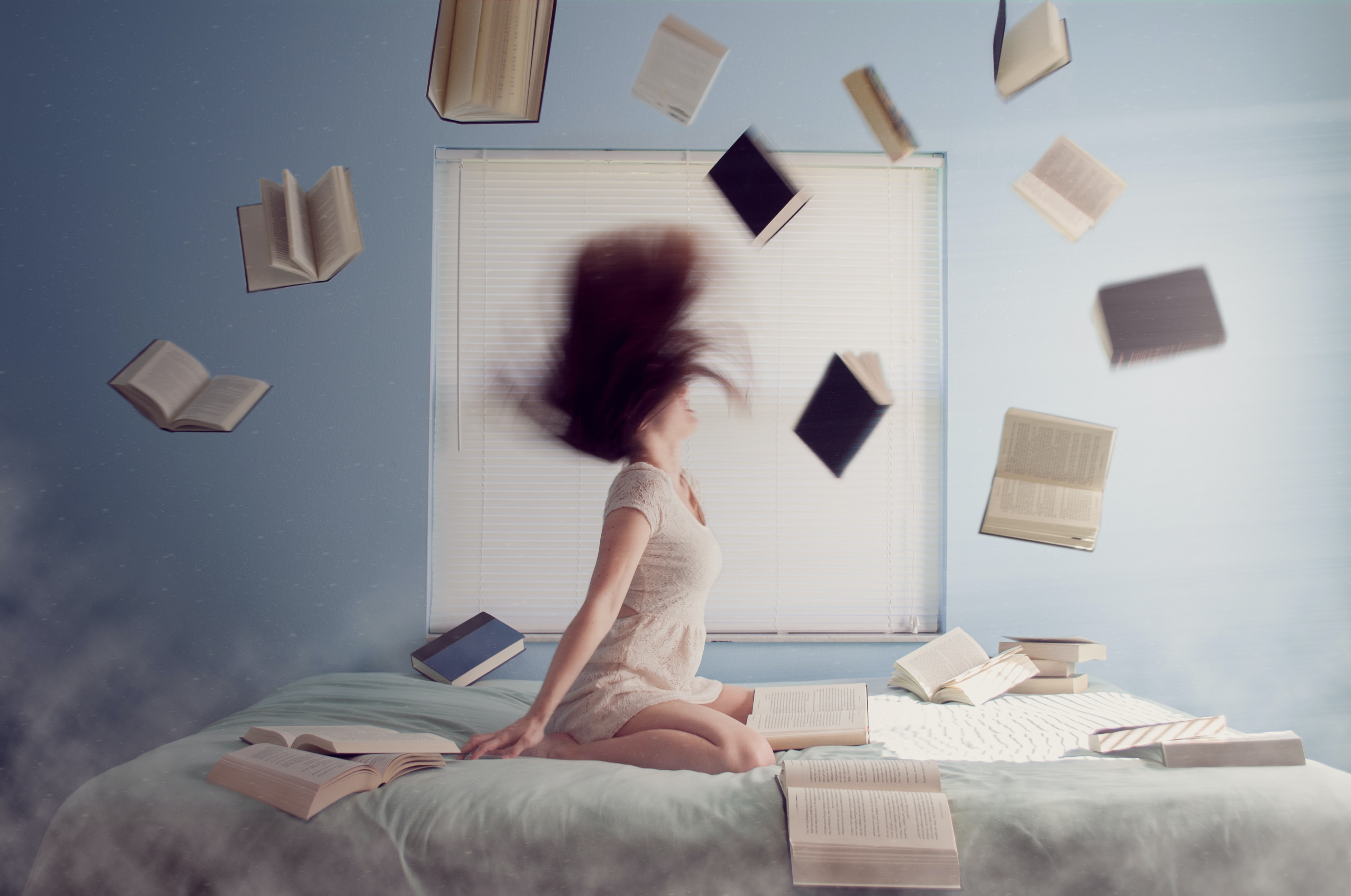 Girl Tossing Her Hair Dramatically with Books Floating Around Her